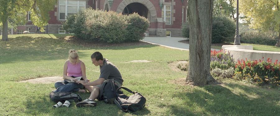 students sitting on t-hall lawn